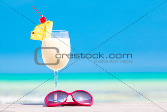 picture of pina colada and sunglasses on tropical beach