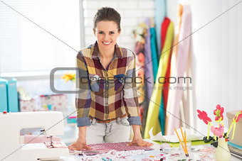 Portrait of happy seamstress in studio