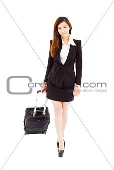 smiling businesswoman walking and carrying the baggage