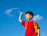 little boy holding a airplane toy with a backpack