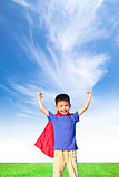 happy little boy imitate superhero and open arms with blue sky