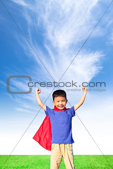 happy little boy imitate superhero and open arms with blue sky