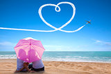 young couple romantic kissing at the beach with the umbrella