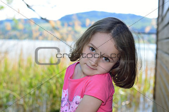 Little girl posing on a lake