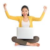 Asian girl arms up using laptop computer