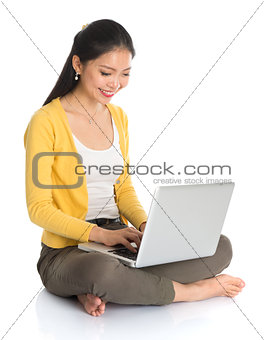 Asian girl typing on laptop
