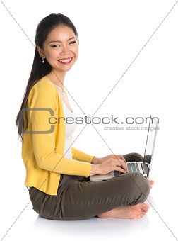 Side view Asian girl using notebook