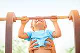 Little boy catch up on the horizontal  bar