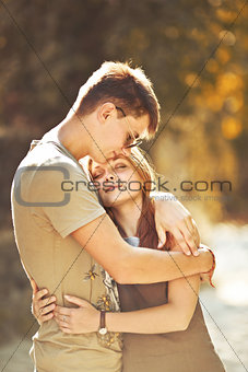 Teen couple bonding, posing together, looking at camera.