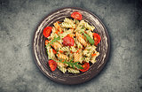 Fusilli pasta with tomato sauce, basil and arugula