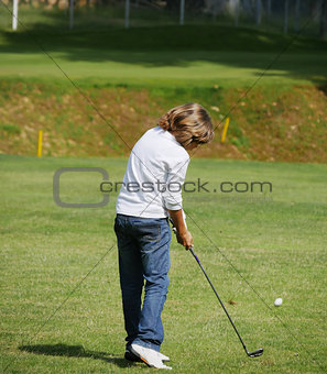 Young golfer performs a golf shot