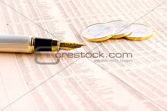 euro coins and a golden pen  on the financial newspaper