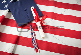 Graduation Cap and Diploma Resting on American Flag