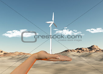 Hand holding wind turbine against a desert