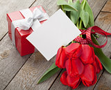 Fresh red tulips with gift box and greeting card