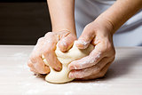 Hands kneading a dough.