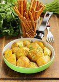 tasty baked potatoes with herbs in the pan