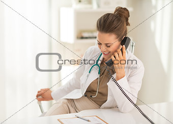 Smiling medical doctor woman talking phone
