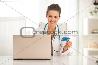 Medical doctor woman with credit card and laptop