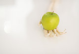 Closeup on human skeleton hand holding apple