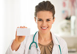Portrait of happy medical doctor woman showing business card