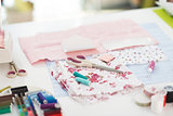 Closeup on table of seamstress with scissors threads and fabric