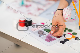 Closeup on seamstress taking button