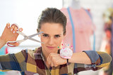 Portrait of confident seamstress with scissors and pincushion