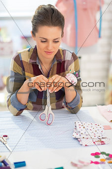 Portrait of thoughtful seamstress in studio
