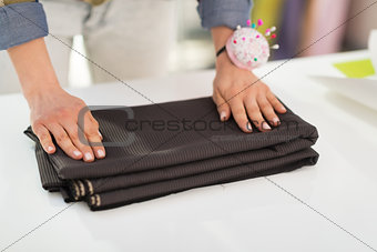 Closeup on seamstress folding fabric