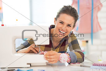 Portrait of happy seamstress sewing in studio