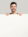 Latin man holding a blank billboard