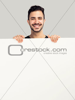 Latin man holding a blank billboard