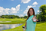 Woman showing a golf ball on the links