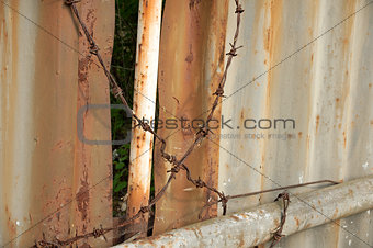 Metal wall and barbed wire