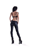 Back view of young tattooed woman in leather pants 