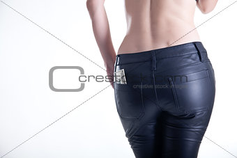Rear view of young woman in leather pants 