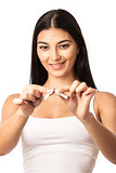 Closeup of a young woman breaking a cigarette while isolated on a white background