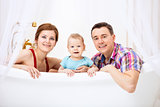 Happy couple with son sitting in bath