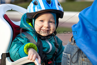Little boy in the seat bicycle behind father