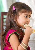 Indian girl eating snack.