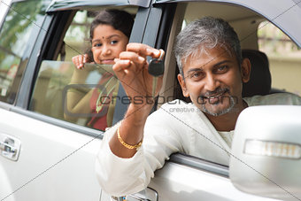 Indian man showing his new car key.