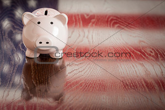Piggy Bank with an American Flag Reflection on Table