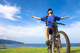 young man sitting on a  mountain bike and open arms to relaxing