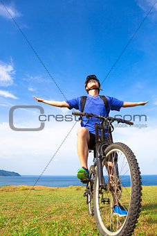 close-up man sitting on a  mountain bike and open arms to relax