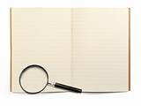 exercise book and magnifying glass