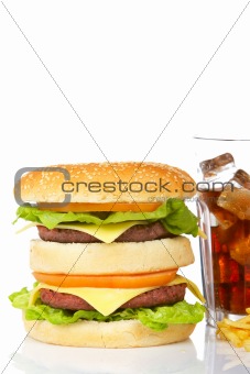 Double cheeseburger and soda glass