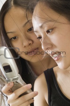 Two Asian women using cell phone