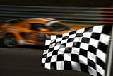 Orange racing car and chequered flag