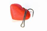 Red heart with a fishing hook on a white background